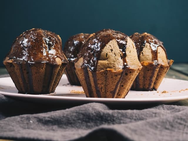 4 Chocolate Glazed Muffins on a white plate