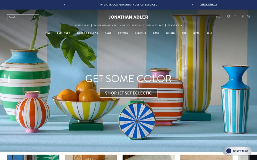 Jonathan Adler homepage screenshot — 'Get Some Color, Shop Jet Set Eclectic' hero with vibrant striped vases and citrus bowl.